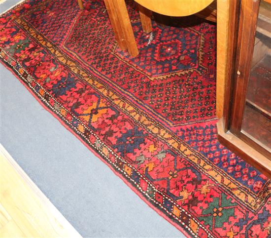 An Eastern red ground rug, woven with a central elongated hexagon 215cm x 135cm